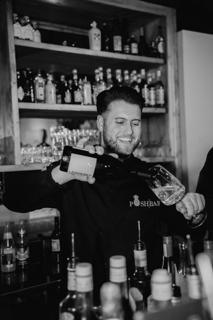 Barkeeper schenkt an der Theke ein, Schwarzweißaufnahme
