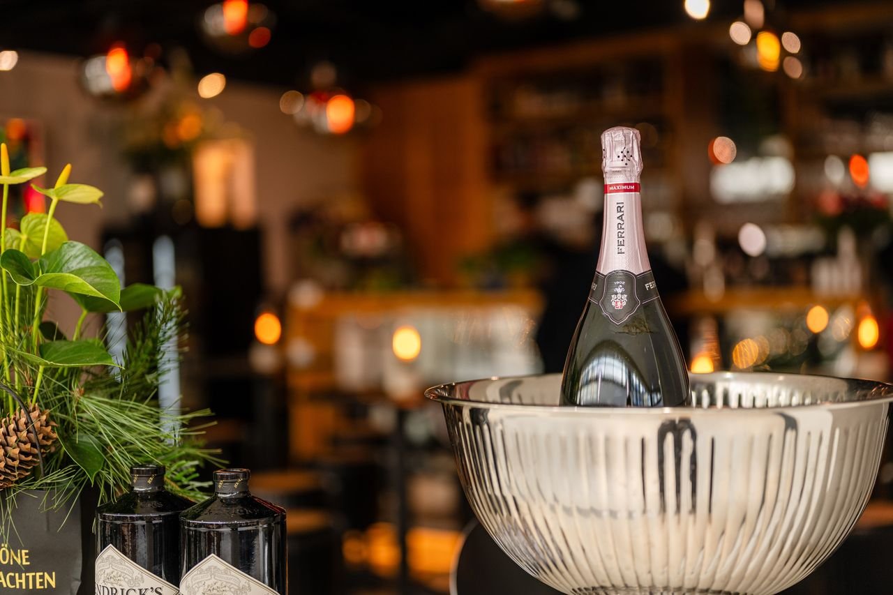 Flasche Ferrari Rosé im silbernen Weinkühler an der Bar