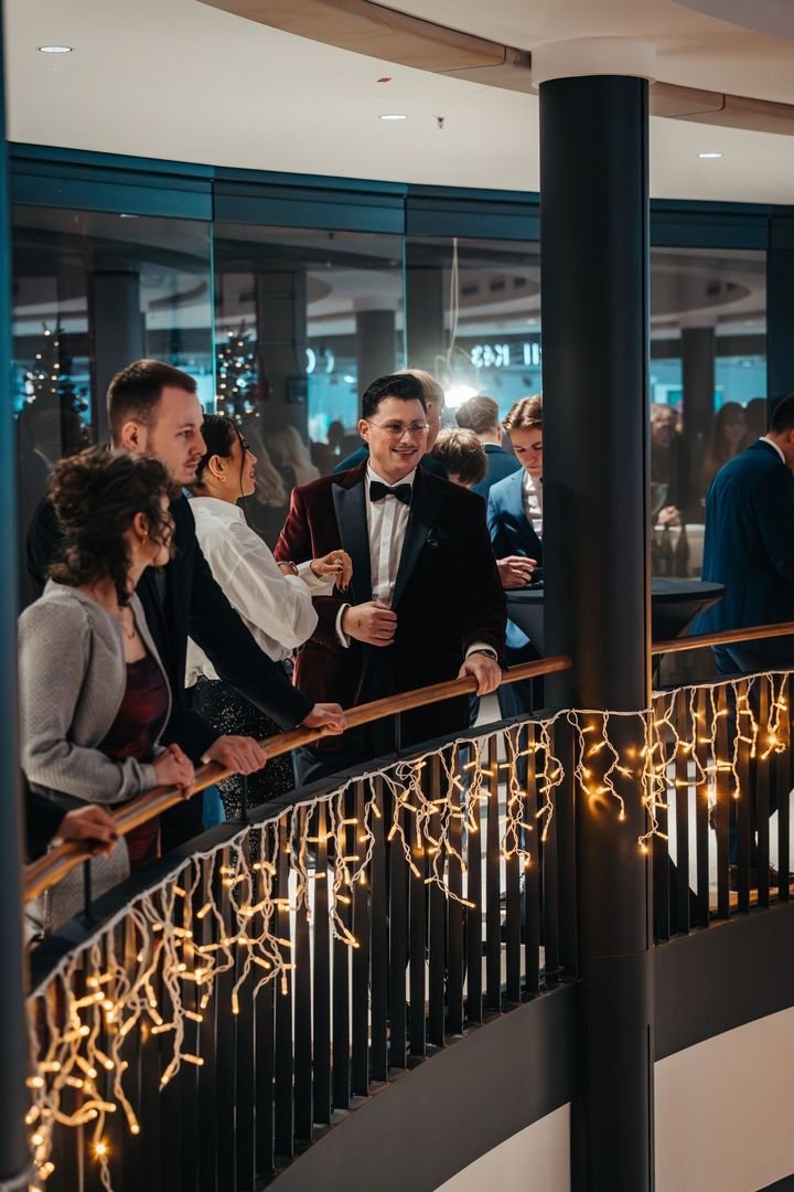 Gäste an der beleuchteten Brüstung der Galerie Luise